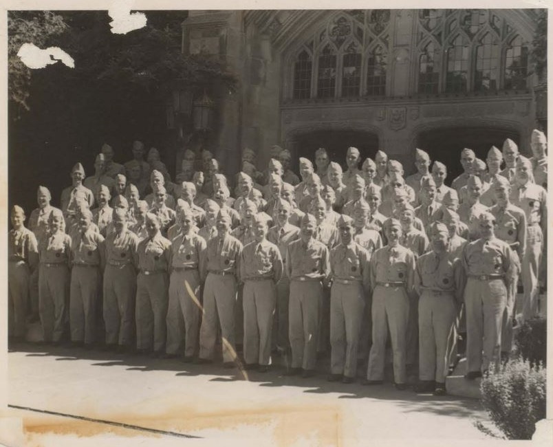 five rows of uniformed graduates in front of old university building, 1943