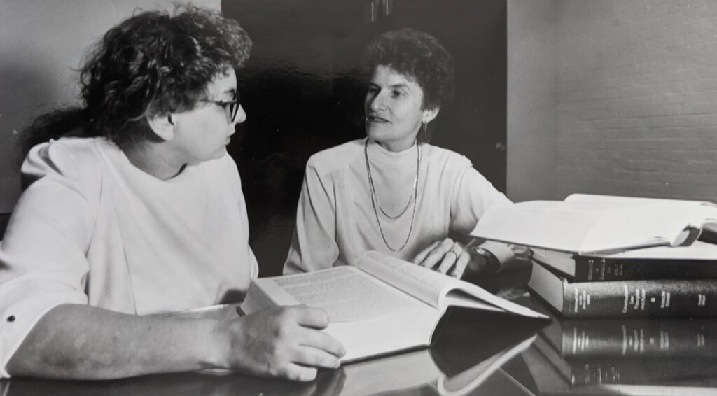 Barbara Aldave sitting with student, law books open on table, 1989