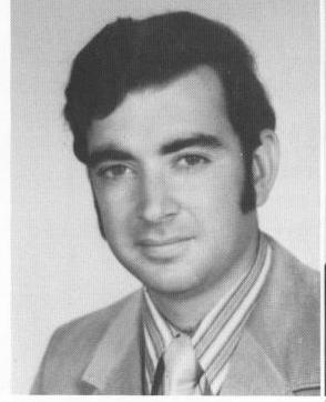 A black and white picture of David Alan Ezra as a third year law student. Ezra wears a tie and striped collared shirt.